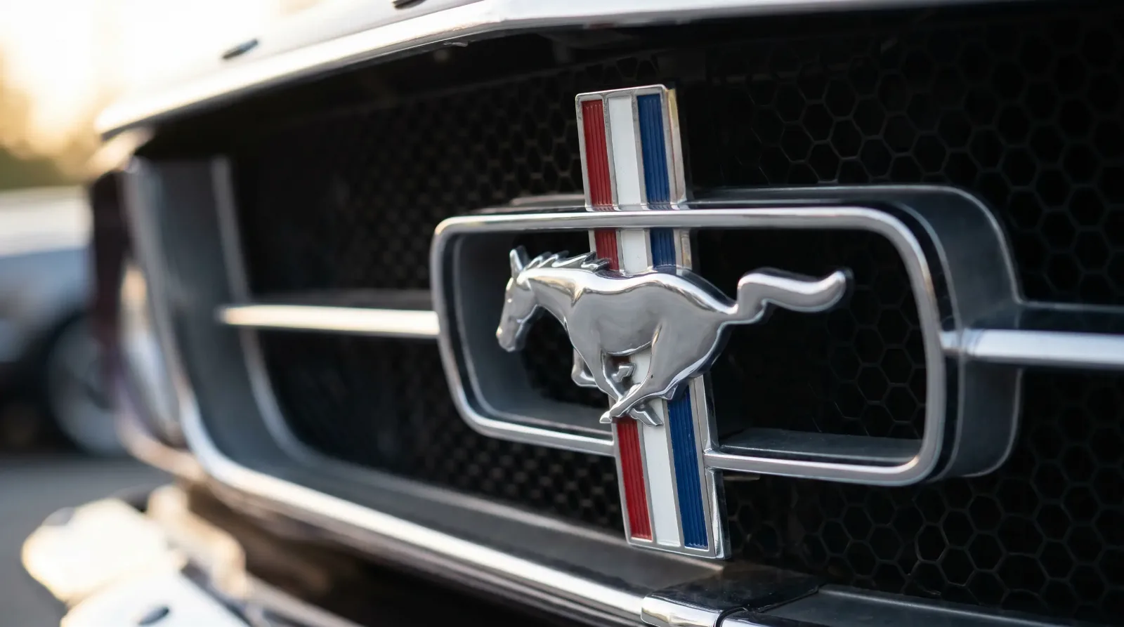 Chrome galloping-horse emblem on a tri-bar grille